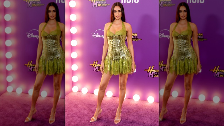 Gizele Oliveira posing in a sparkly green minidress.
