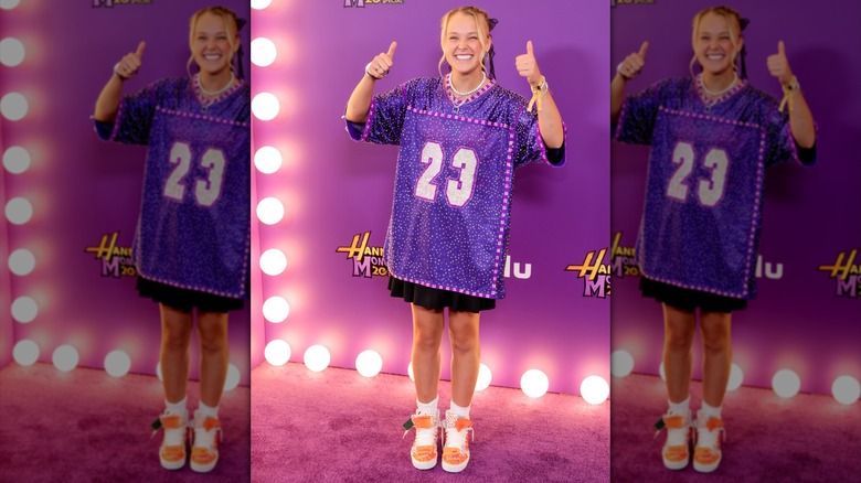 JoJo Siwa posing in an oversized sparkly jersey.