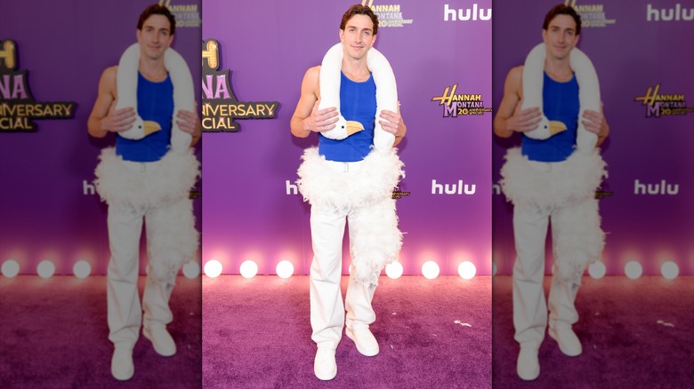 Matt Peterson posing in a swan shirt and white pants.