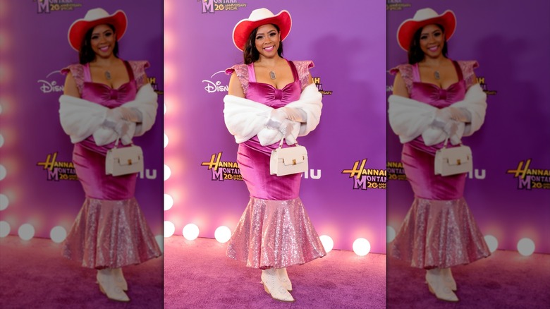Shanica Knowles posing in a red and white cowboy hat and a pink mermaid gown.
