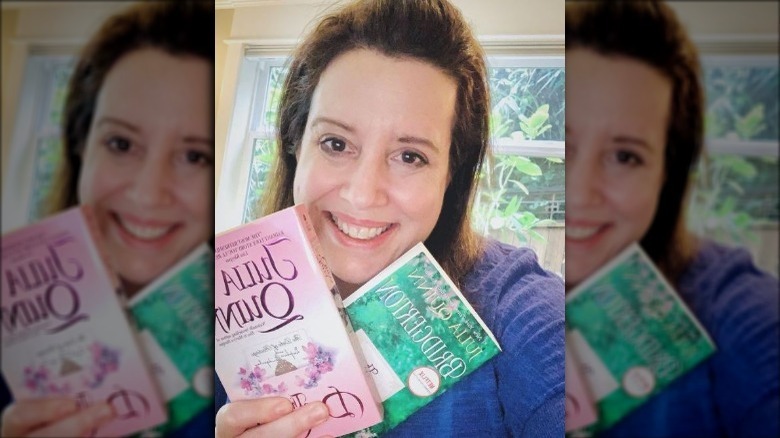 Julia Quinn holding up a couple of her books
