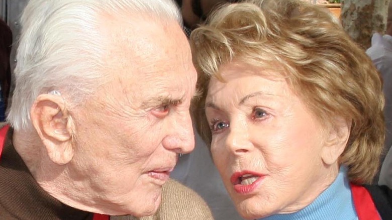 Kirk Douglas and Anne Douglas speaking closely