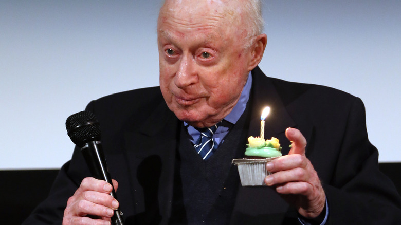 Norman Lloyd holding a cupcake
