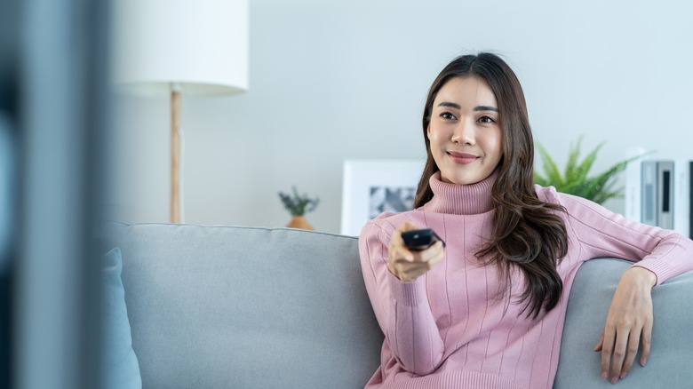 woman turning on TV