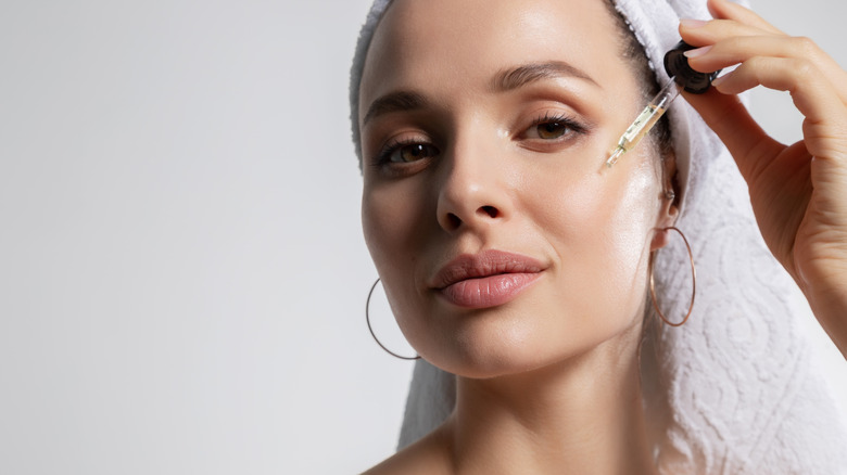 woman applying oil to her face