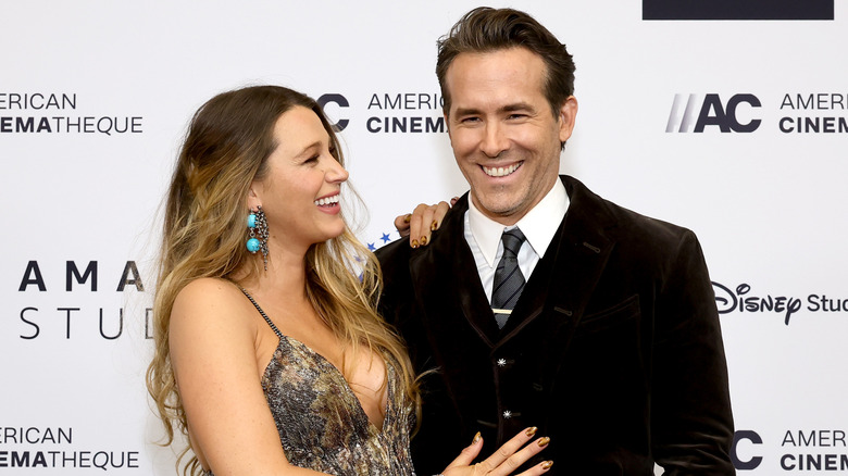 Blake Lively smiling at Ryan Reynolds at a red carpet event