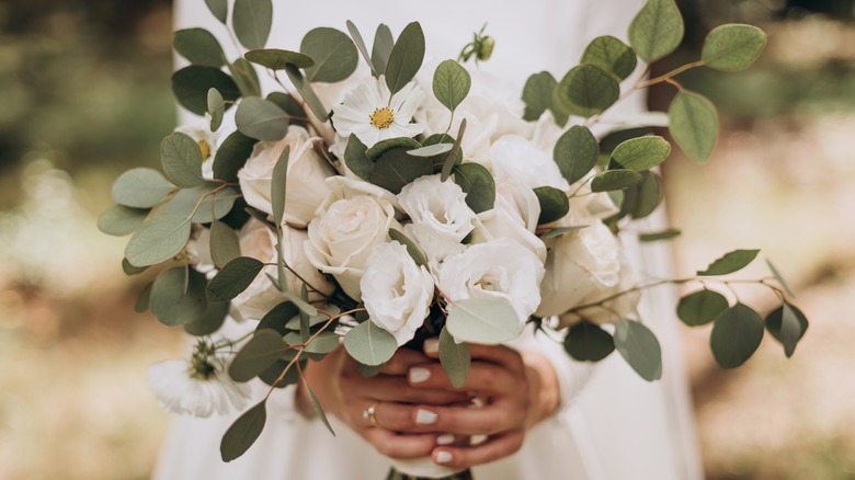 Bride holds bouquet of white flowers