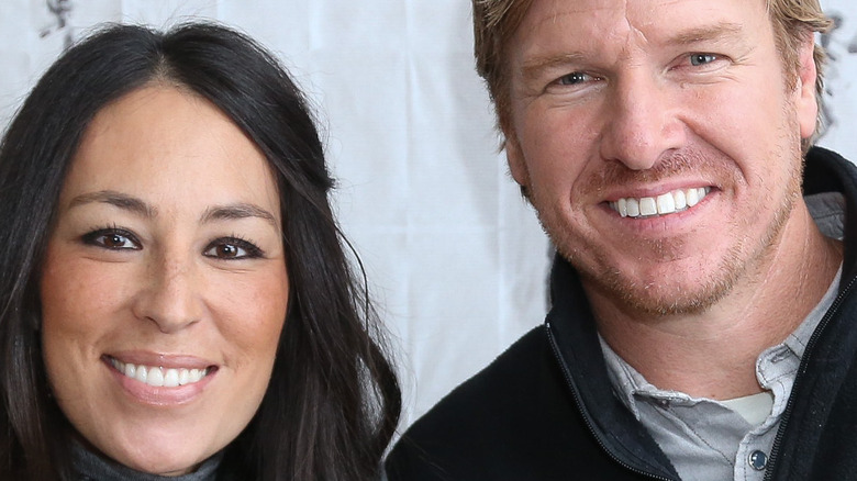 Chip and Joanna Gaines stand together smiling