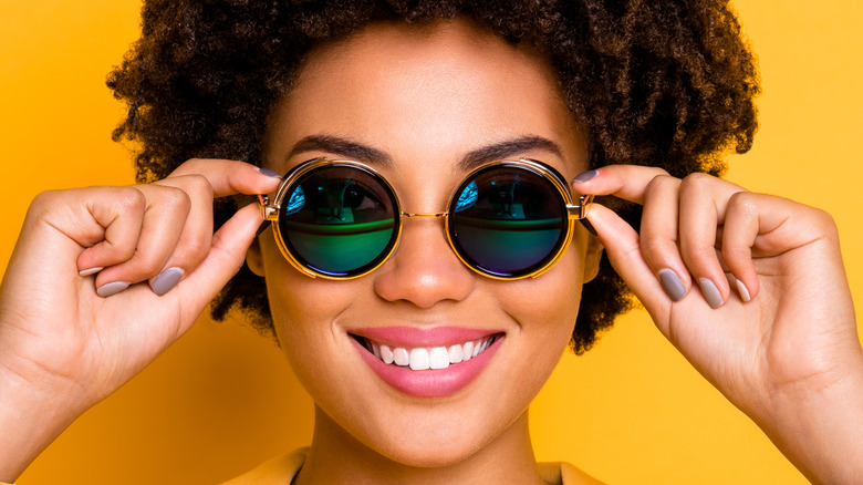 Woman showing off round sunglasses
