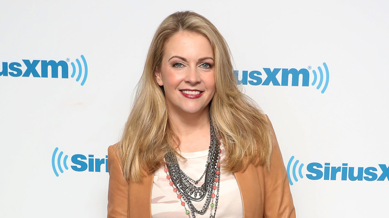Melissa Joan Hart smiling while posing at an event