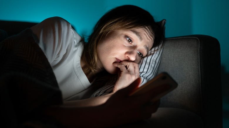 Woman scrolling on her phone at bedtime 