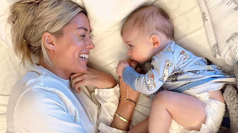 Heather Rae El Moussa smiles at infant son kissing her finger