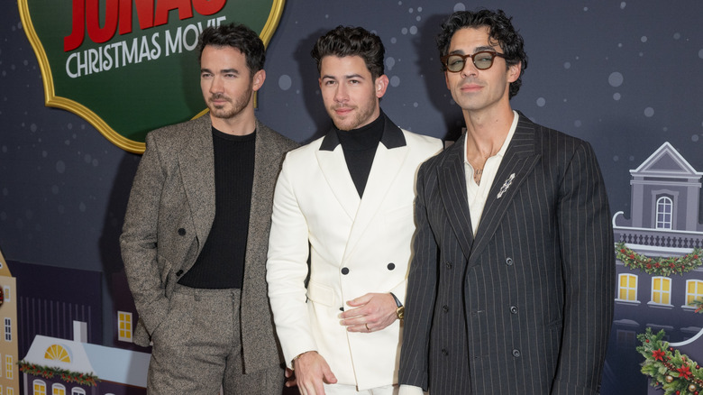 Kevin Jonas, Nick Jonas, and Joe Jonas posing for photo at premiere of Disney+ original film "A Very Jonas Christmas Movie"
