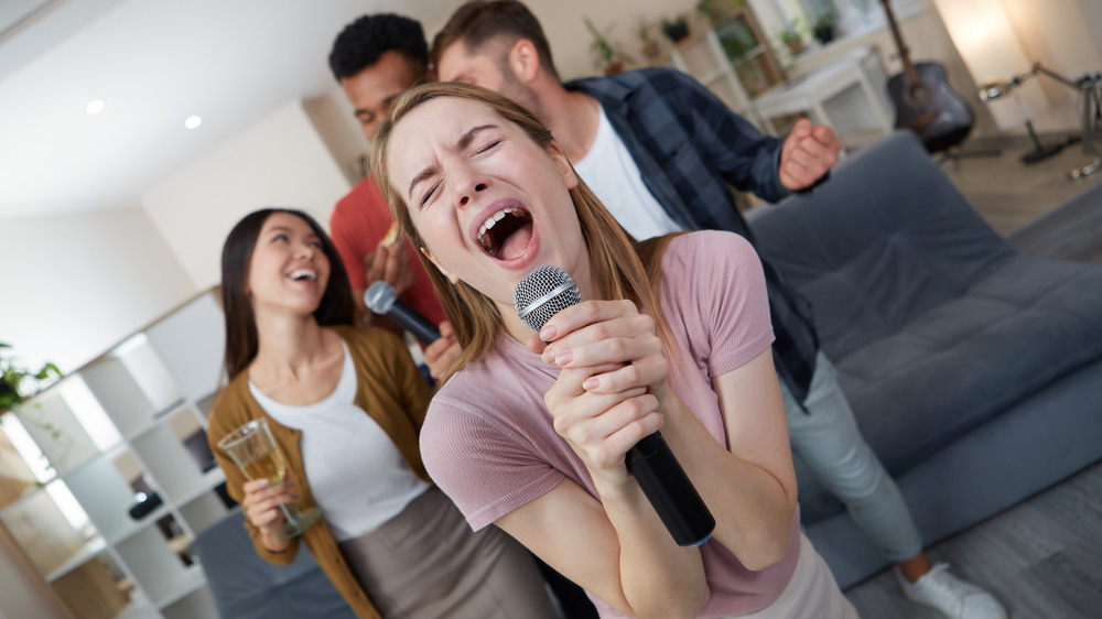 Woman singing karaoke at party