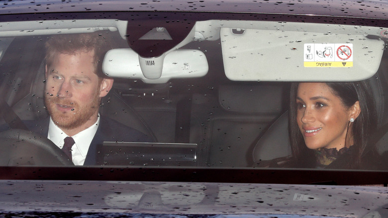 Prince Harry and Meghan Markle in a dark car