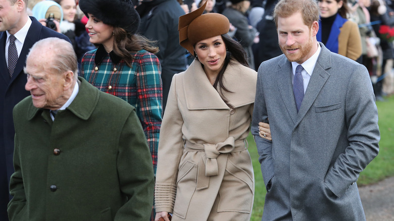 Meghan Markle and Prince Harry walk behind the aging Prince Philip