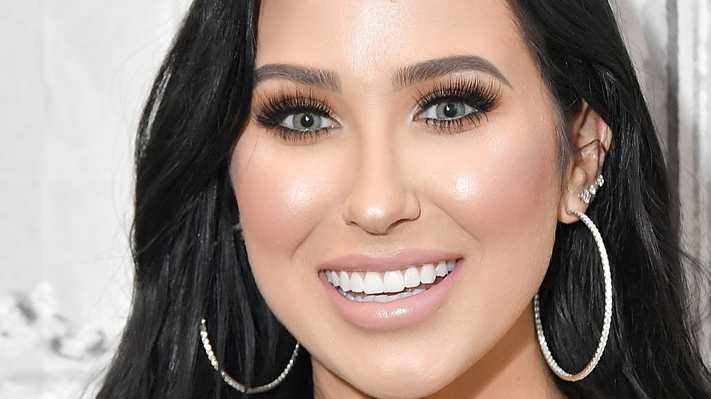 Jaclyn Hill smiling in hoop earrings