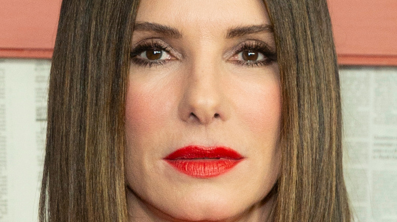 Sandra Bullock wears red lipstick and rocks a short bob.