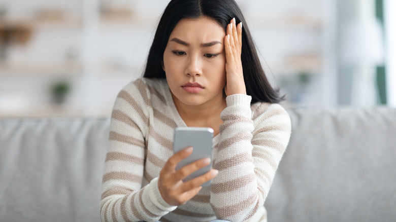 Woman looking at phone upset