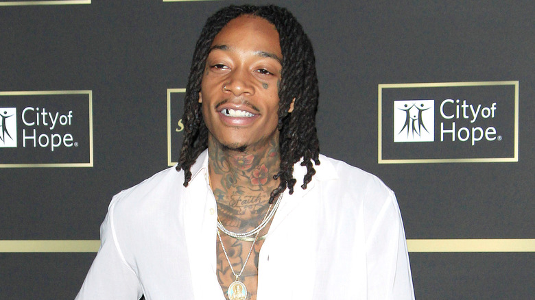 Wiz Khalifa smiles at a red carpet event