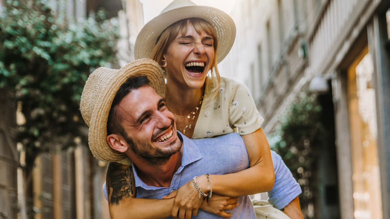 smiling couple wearing hats outside