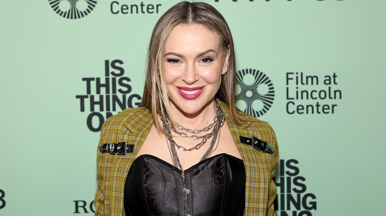 Alyssa Milano smiling while posing at an event