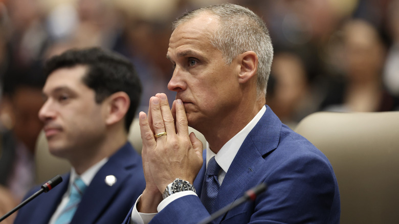 Corey Lewandowski listens intently from the crowd while his hands are in prayer by his mouth