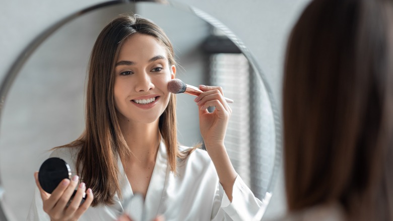 woman applying blush