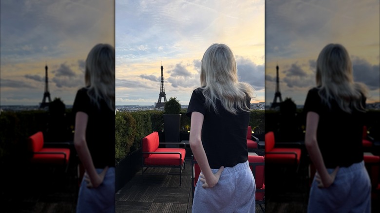 Kai Schreiber posing in sweatpants and a t-shirt in front of the Eiffel Tower