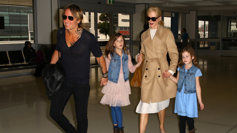 Keith Urban and Nicole Kidman holding hands with their daughters