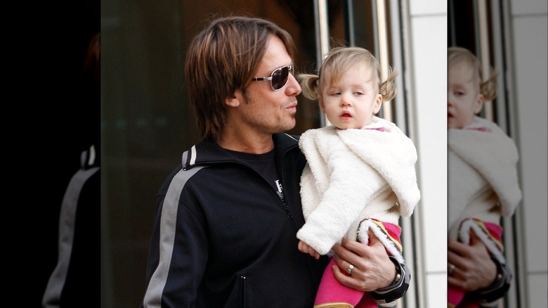 Keith Urban carrying a sleepy Sunday Rose Kidman-Urban on the streets of New York in 2009