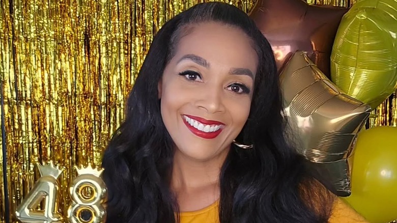 Shea Hicks-Whitfield smiling amid birthday decorations