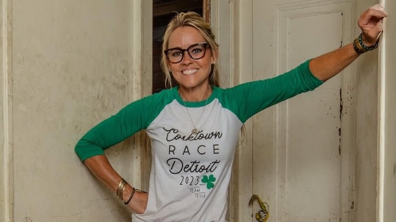 Nicole Curtis in a doorway of a beaten up house.