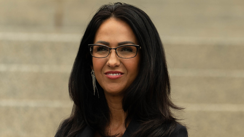 Lauren Boebert posing while wearing glasses and a black suit at the U.S. capitol
