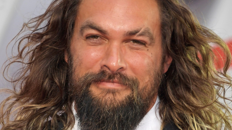 Jason Momoa poses on the red carpet in a tuxedo