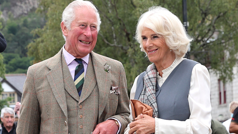 King Charles and Queen Camilla smiling at event