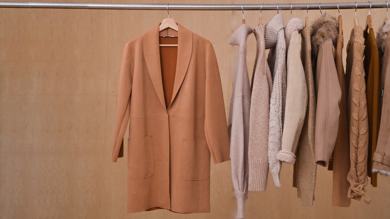 Neutral jackets hang on a clothing rack