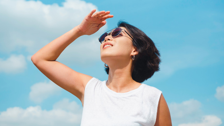 Woman shields her face from the sun