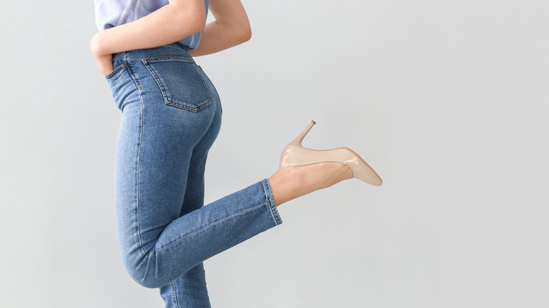 Woman kicks heel up wearing high heeled shoe