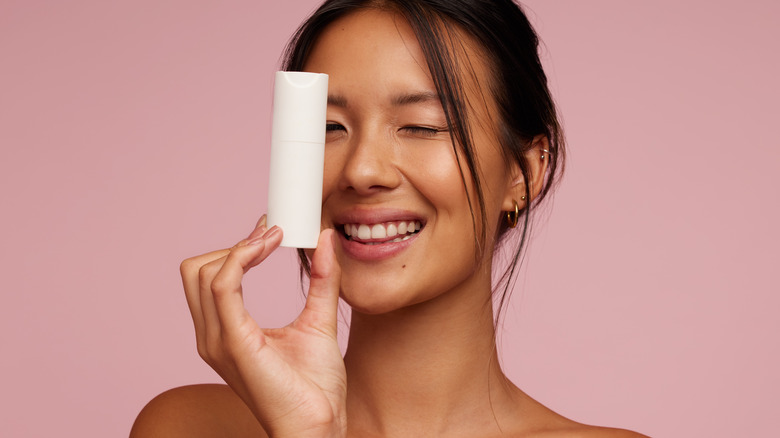 Woman holding a white skincare bottle