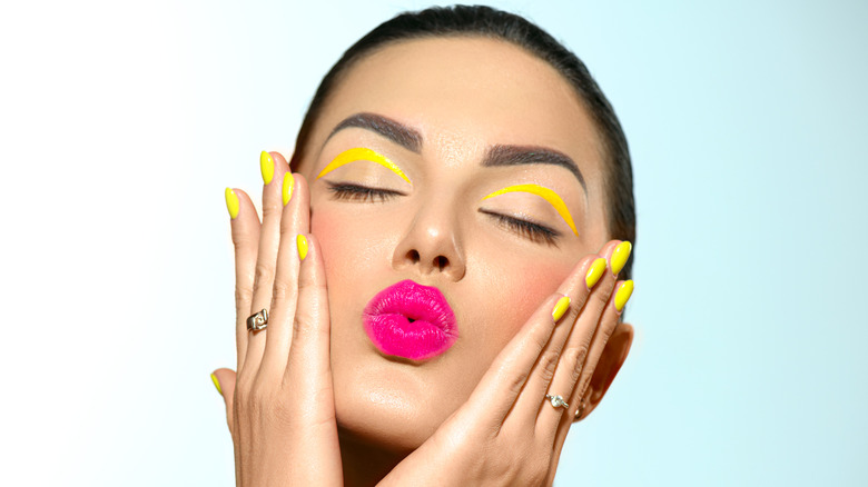 Woman wearing lipstick purses lips