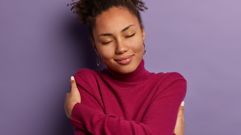 Woman hugging herself wearing sweater