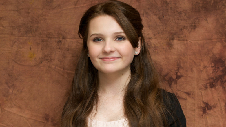 Young Abigail Breslin smiling while posing at an event