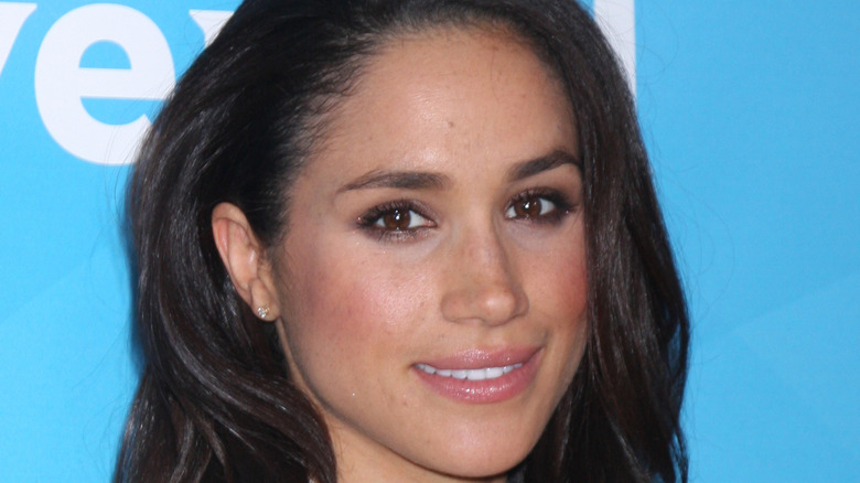 Meghan Markle poses with a smile. 