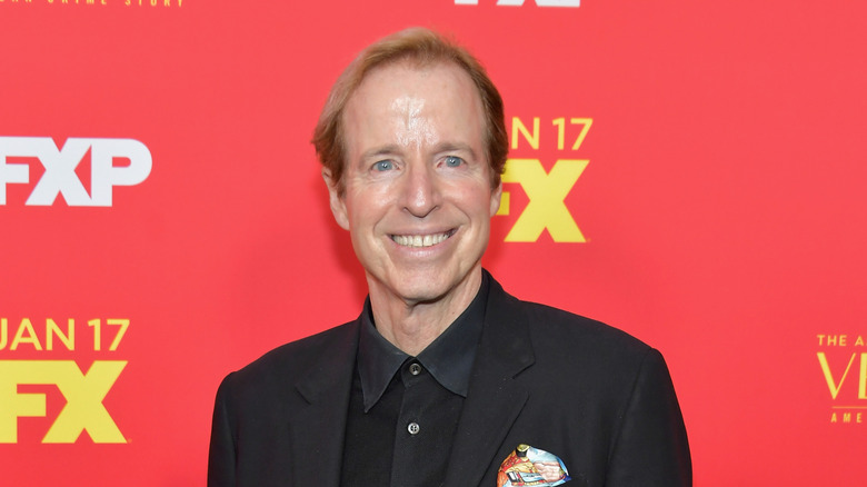 Terry Sweeney posing in front of a red background