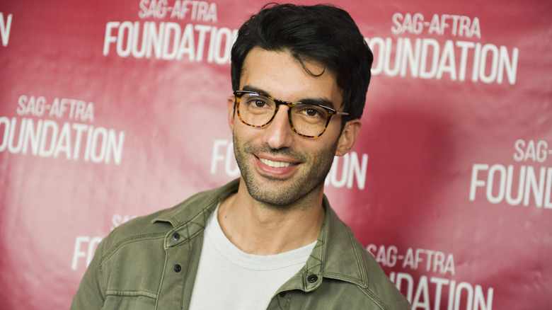 Justin Baldoni wearing glasses and smiling