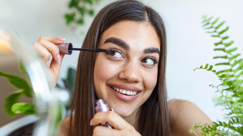 Woman applying mascara