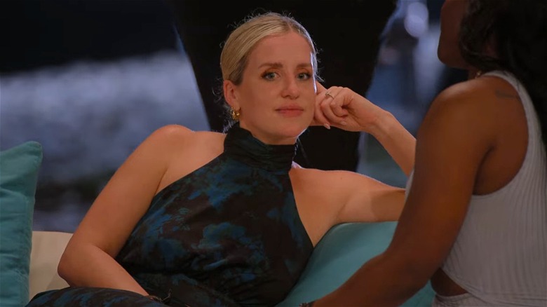 Laura sits on couch with AD, looking off to side