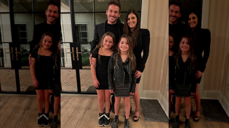 Kevin Zegers, Jaime Feld, and their twin daughters in all-black ensembles, posing for a family photo