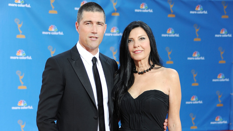 Matthew Fox wears a suit and tie and poses with his arm around Margherita Ronchi, who wears a strapless black dress.